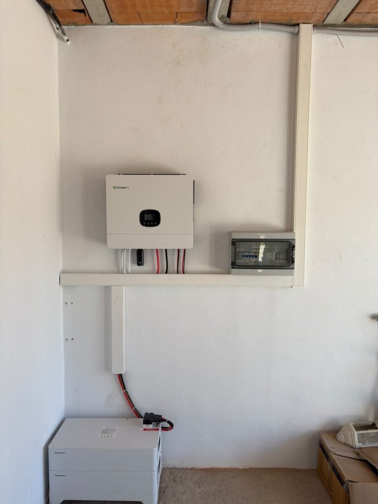 Inversor Growatt y cuadro de protecciones montados en la pared de un garaje