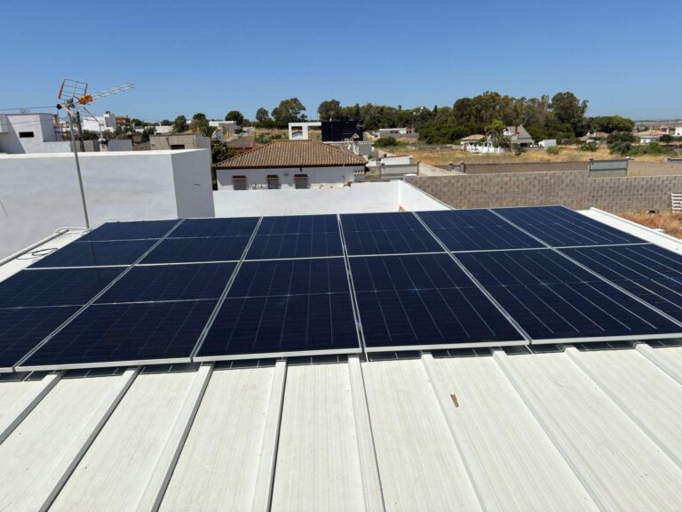 Paneles solares sobre cubierta metálica blanca en una zona residencial