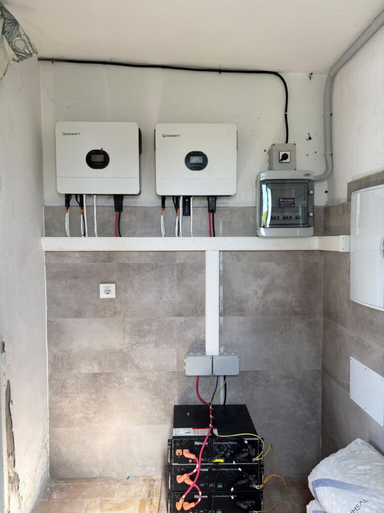 Dos inversores Growatt y batería instalados en la pared de un cuarto técnico