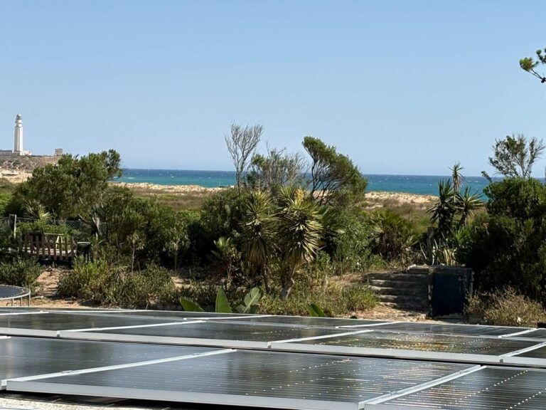 Paneles solares en una cubierta con la playa y el mar al fondo