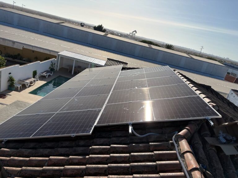 Placas solares en el tejado de una casa con piscina y porche