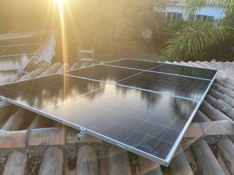 Placas solares sobre teja al atardecer, a contraluz