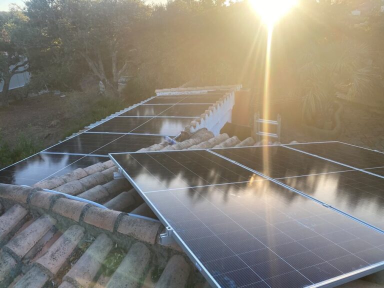 Hileras de paneles solares en un tejado al atardecer